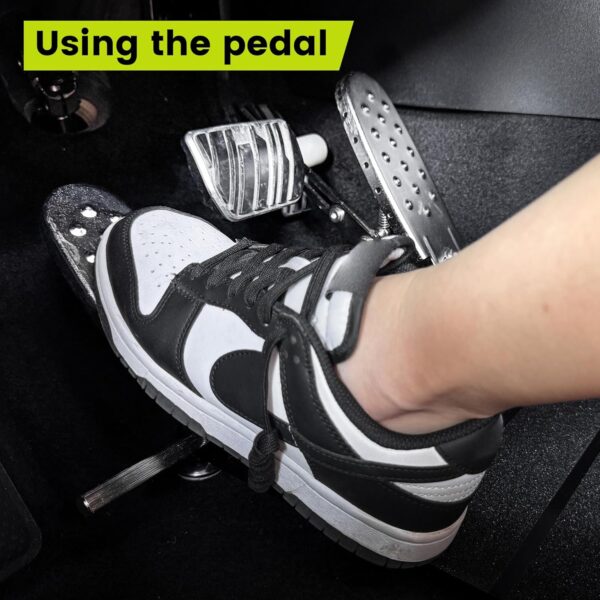 A left foot accelerator pad installed in a vehicle with a person's left foot using the pedal.