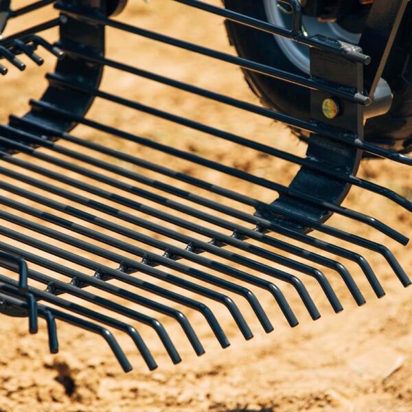 Black vibrating plowshare that cuts through the top layer of the soil and uproots the potatoes, and transfers them to the sieve tin.