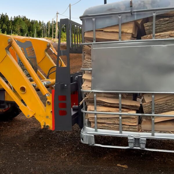 A loader bucket quick attached to a piece of heavy equipment that's moving a trailer full of wood.