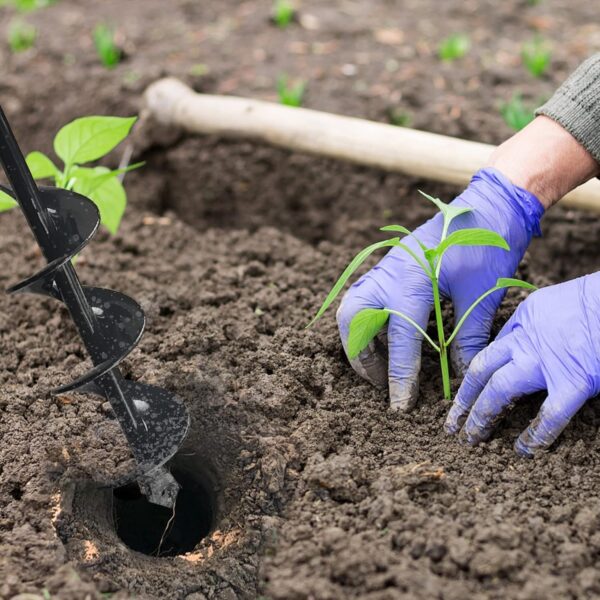 A person using a auger drill to plant plants.